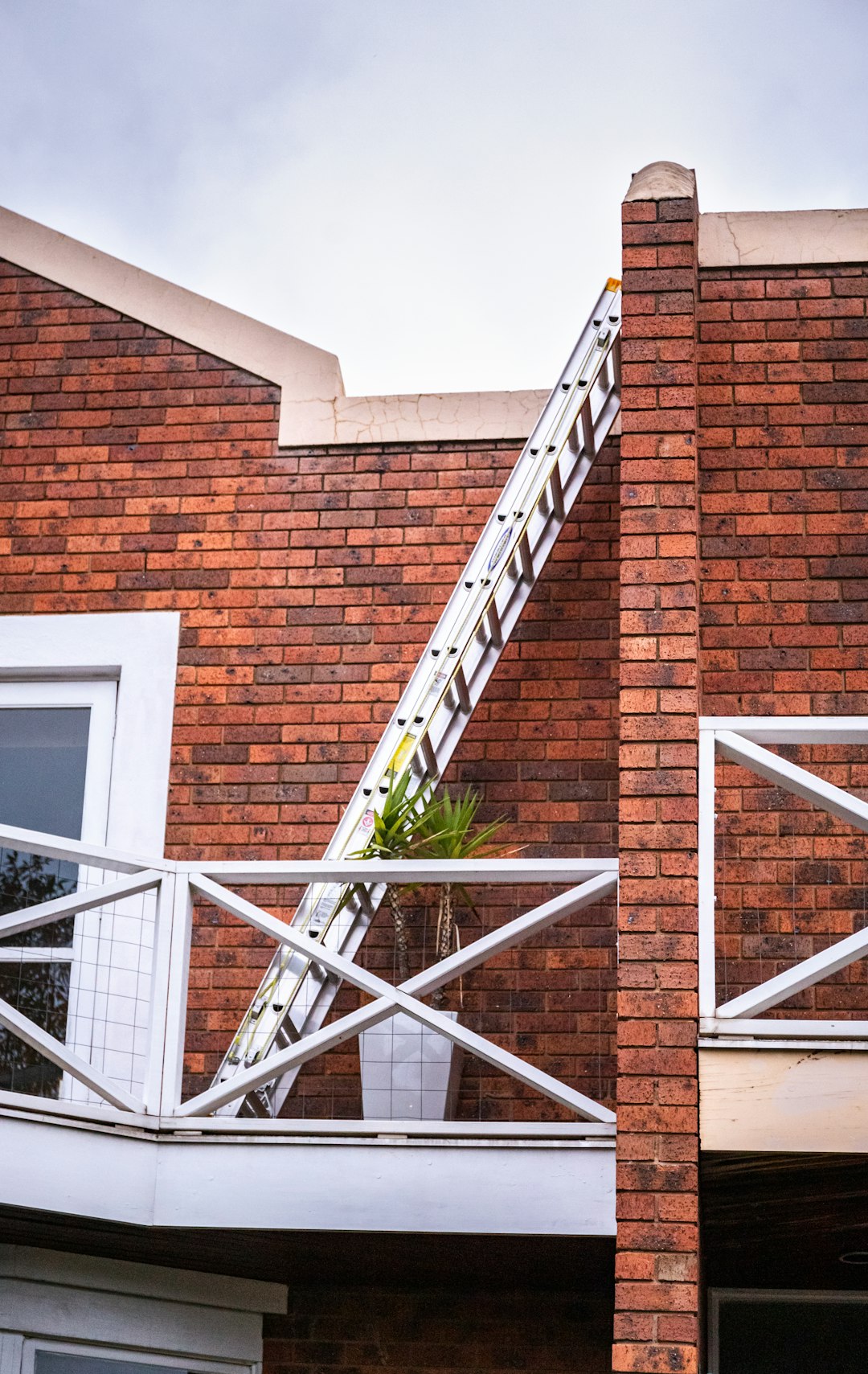 brown brick building with white metal railings