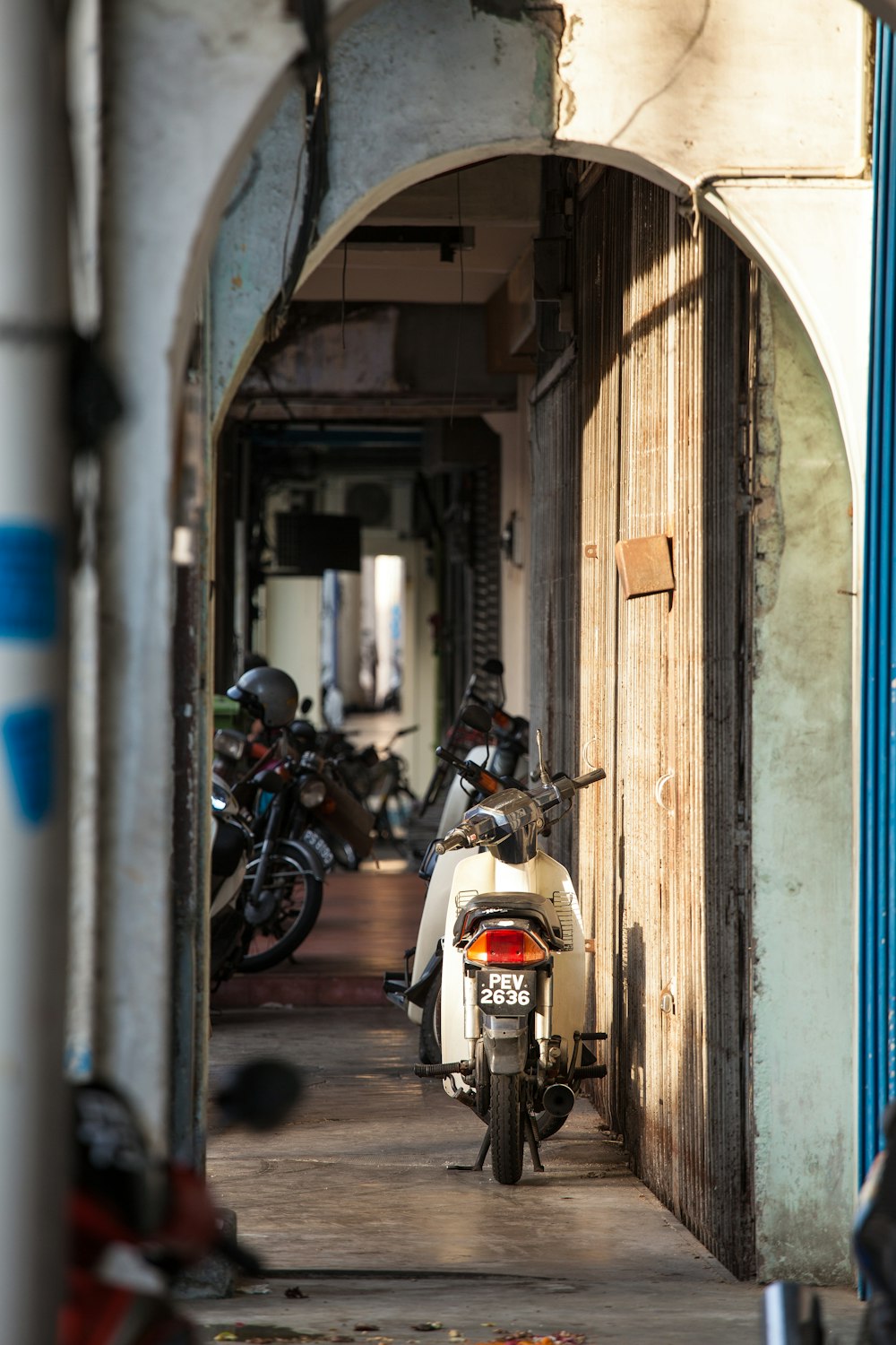 white and black motorcycle parked beside blue and white concrete building during daytime