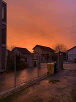 A sunset view of a dumpster placed on a quiet residential street after a community clean-up event.