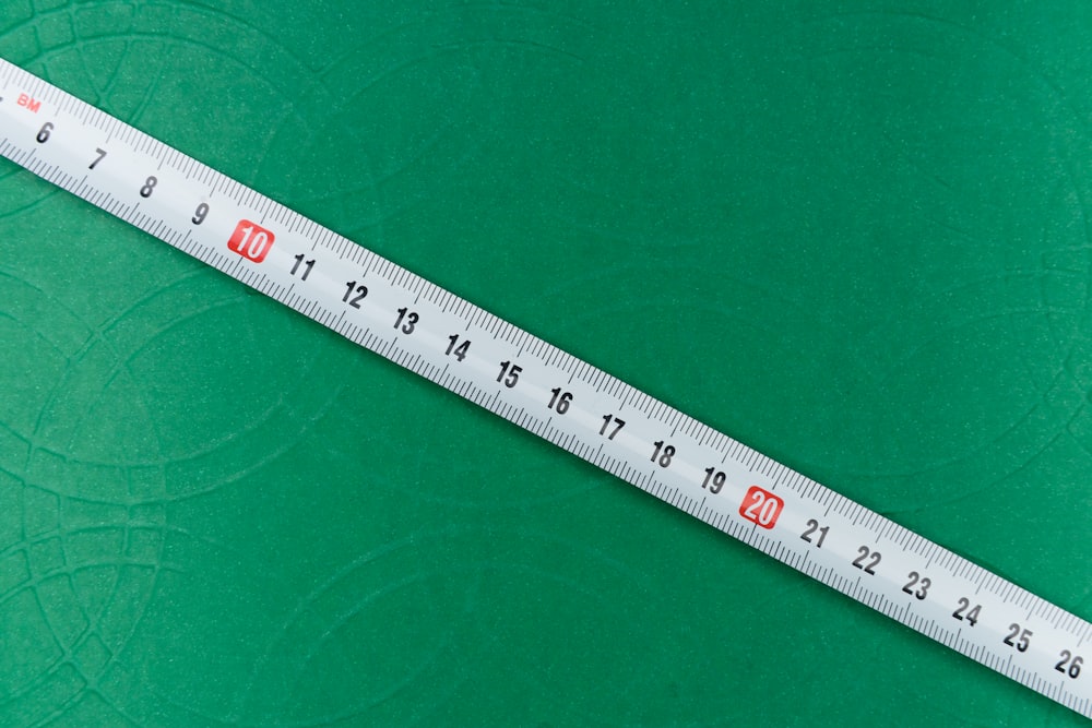 white ruler on green textile