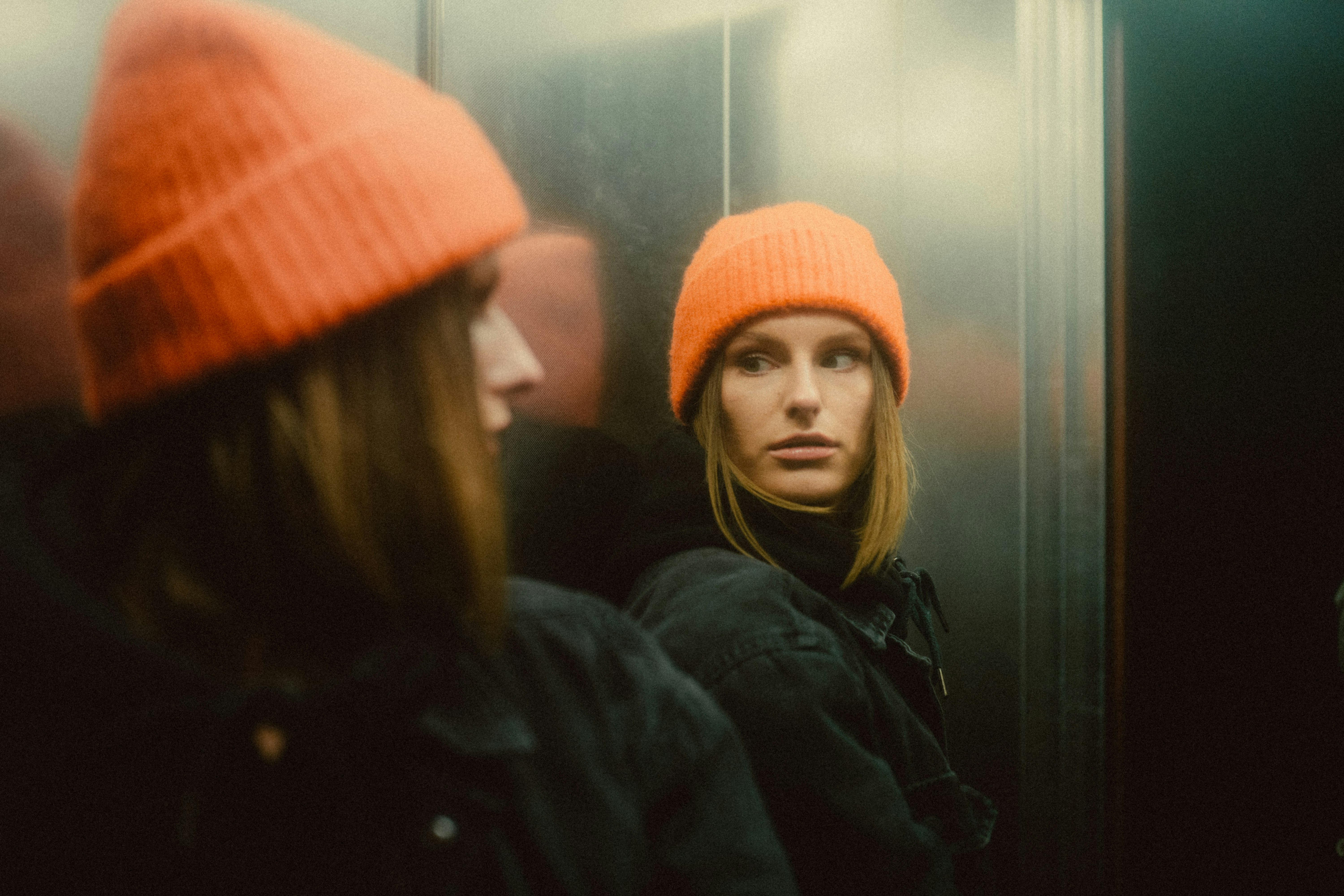 woman in orange knit cap and black jacket