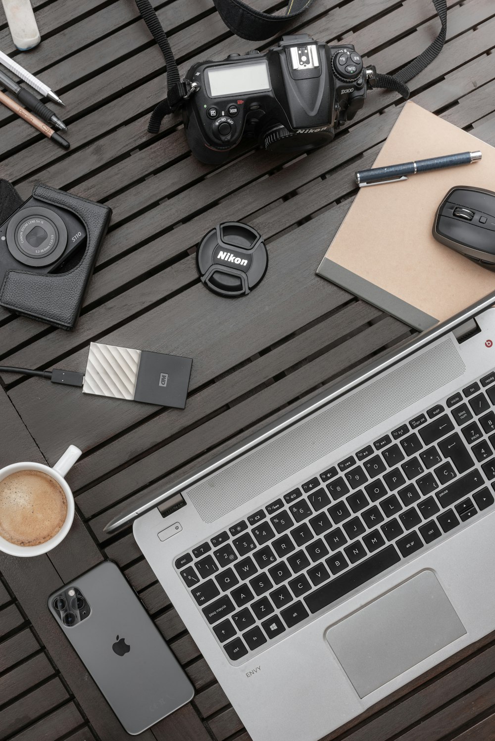 Auriculares negros y plateados junto al teclado Apple blanco y auriculares negros