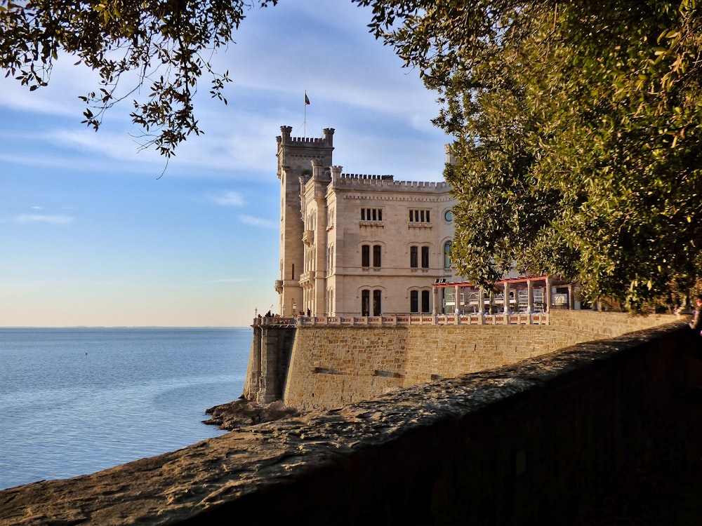 edificio in cemento bianco vicino a uno specchio d'acqua durante il giorno