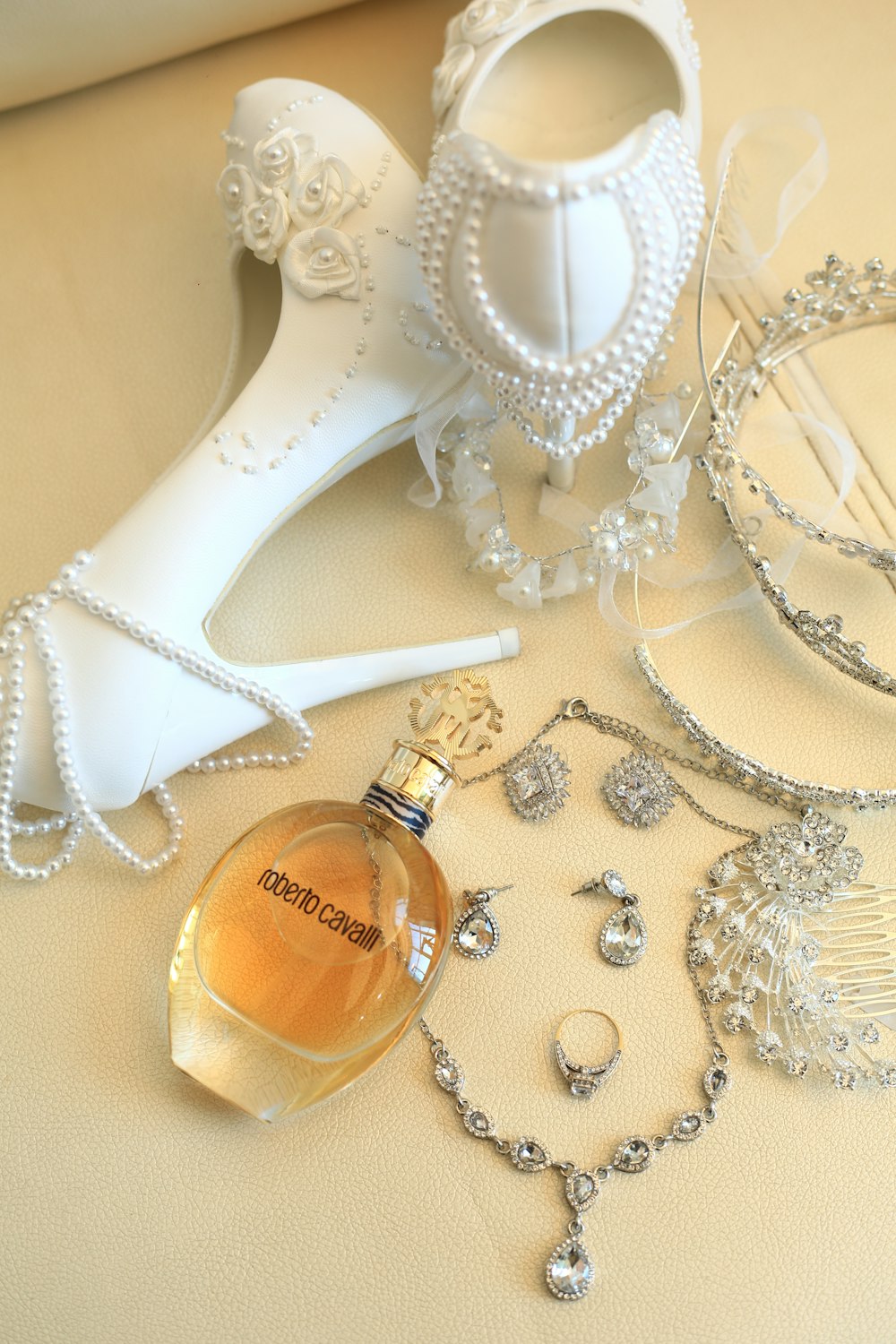 gold perfume bottle beside white lace