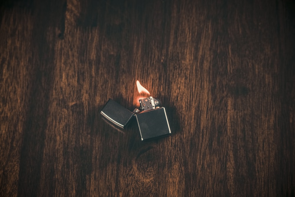 silbernes Flip-Feuerzeug auf braunem Holztisch