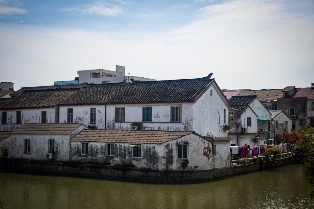 white and brown concrete house beside river during daytime