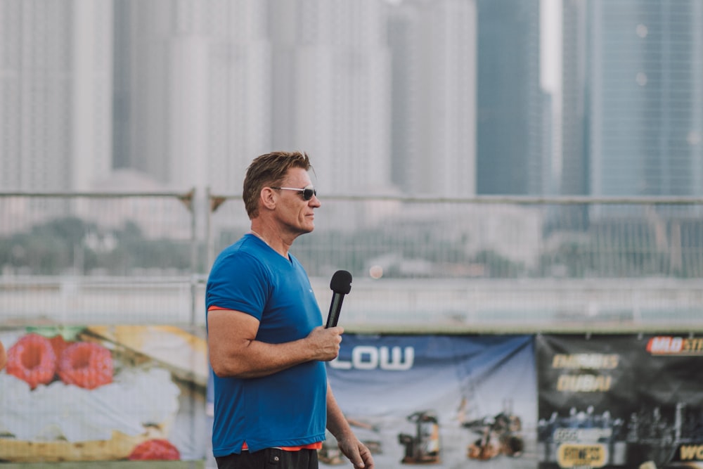 man in blue crew neck t-shirt standing on field during daytime