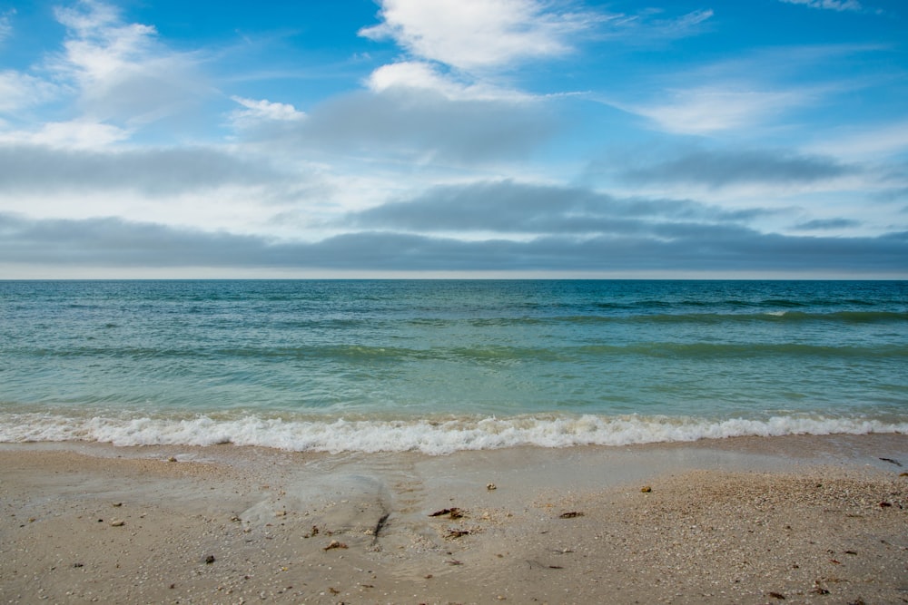 blue sea under blue sky and white clouds during daytime