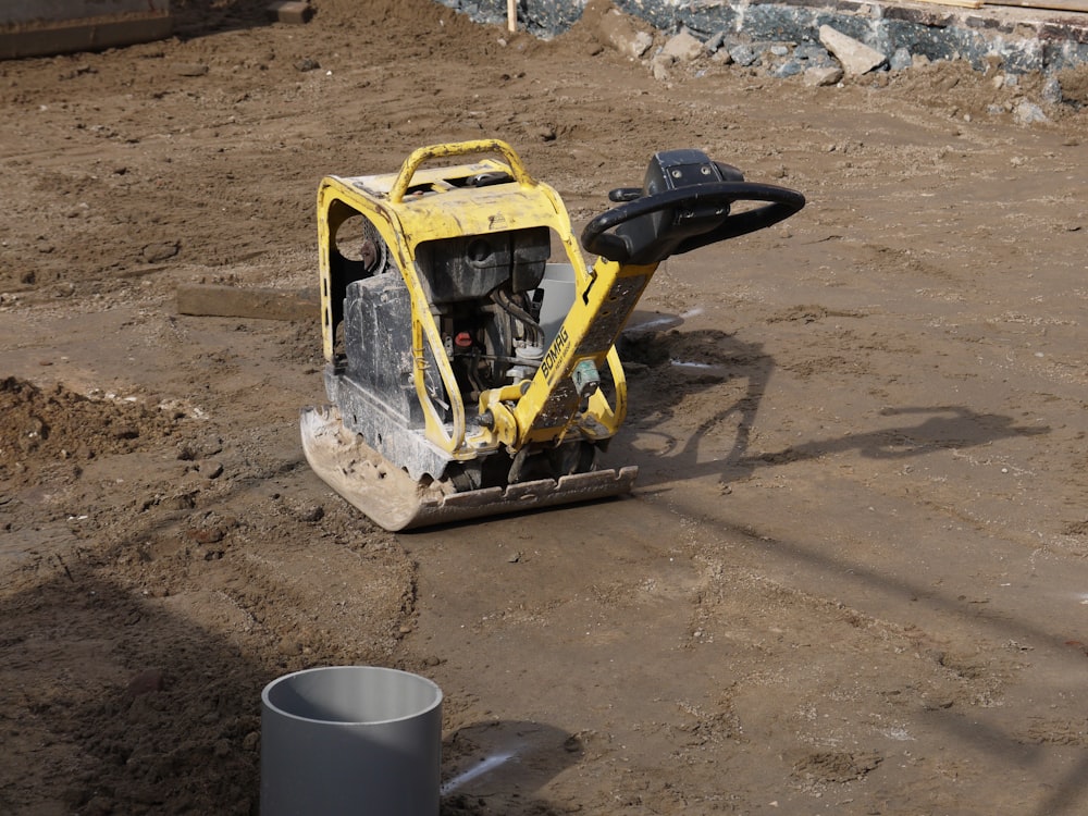 yellow and black excavator on brown sand