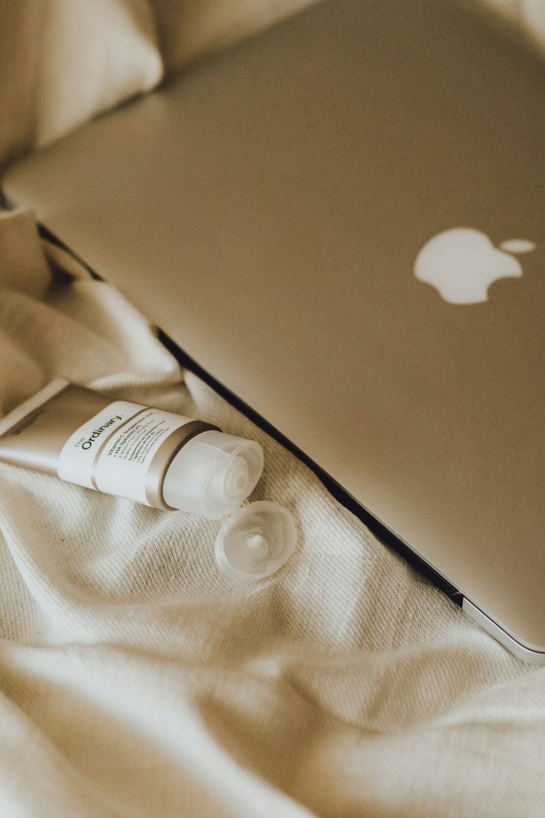 silver macbook on brown textile