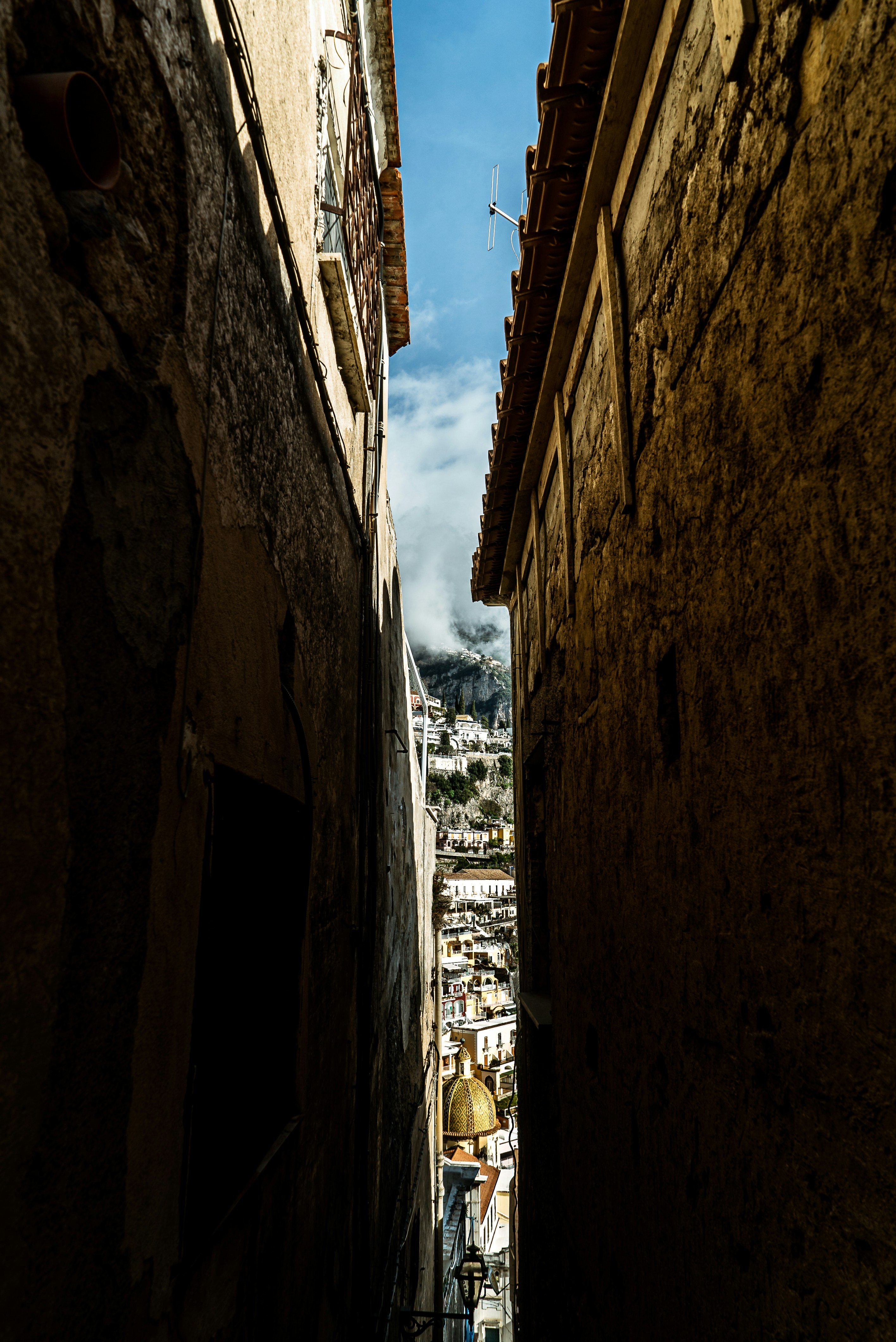people walking on pathway between concrete buildings during daytime