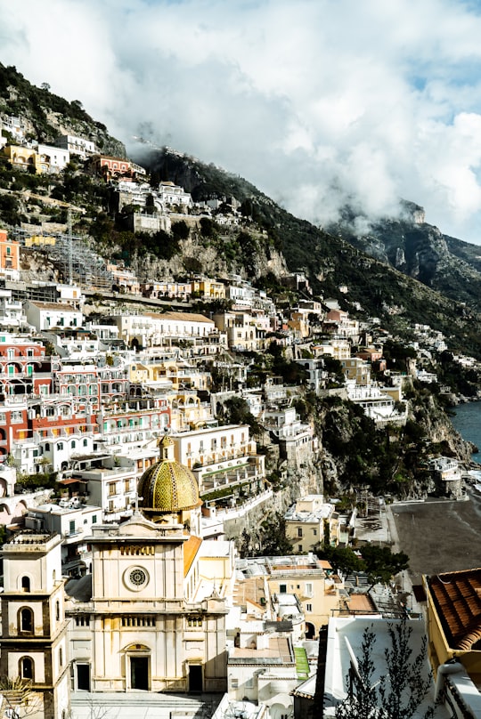 white and brown concrete buildings near mountain during daytime in Positano Italy