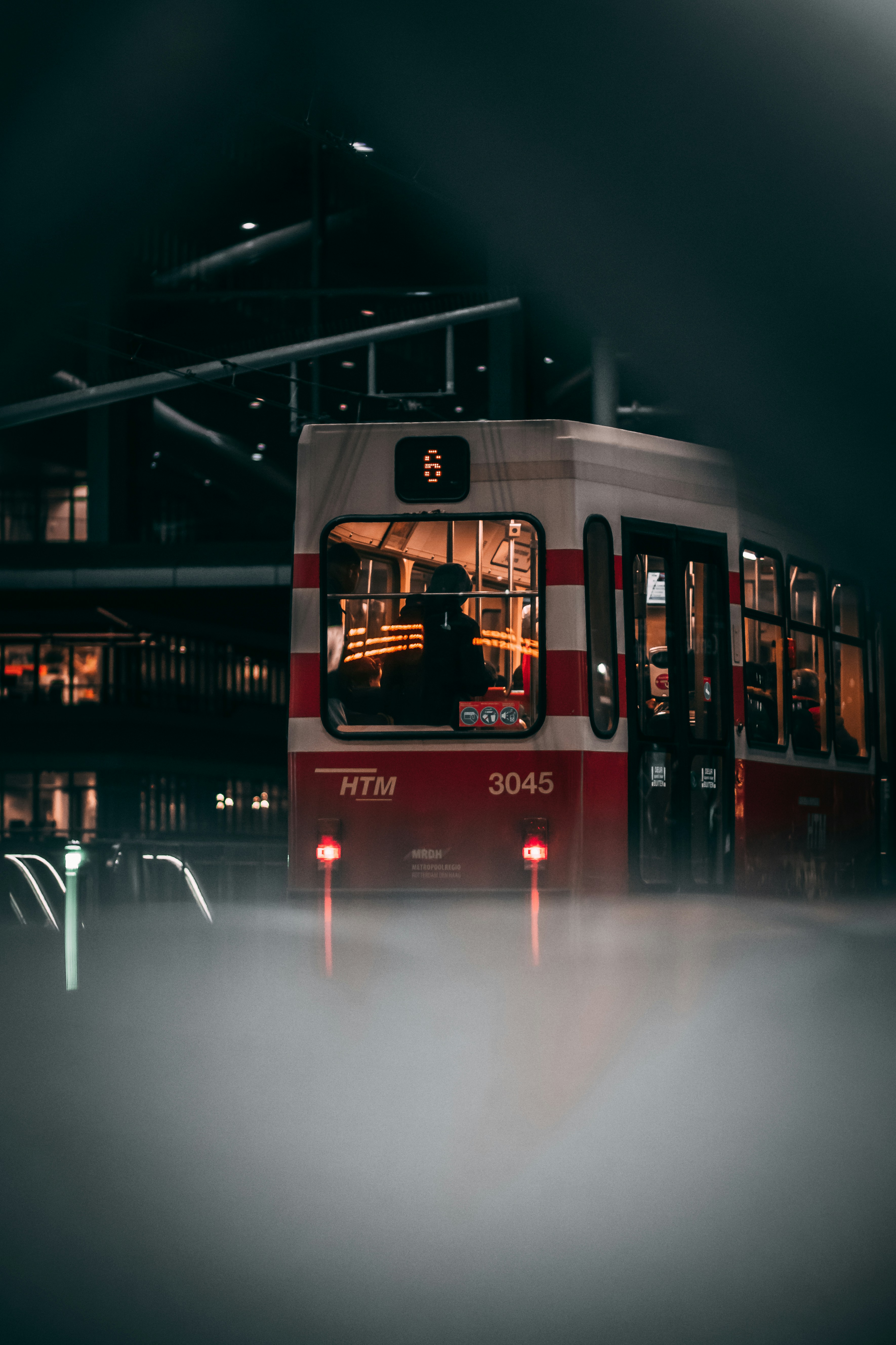 Red and black bus on road during night time photo – Free Human Image on ...