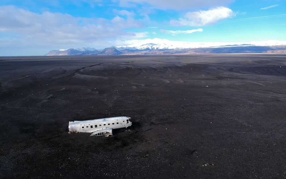 white airplane on gray sand during daytime