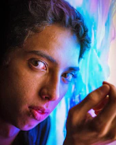 A vibrant, close-up portrait highlighting authentic expression against a soft backdrop.