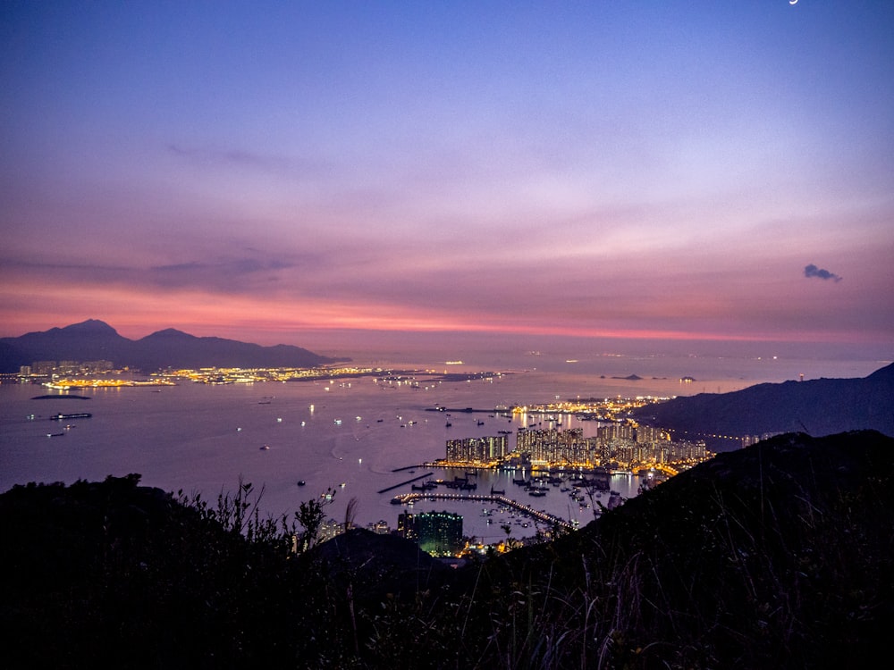 city near body of water during sunset