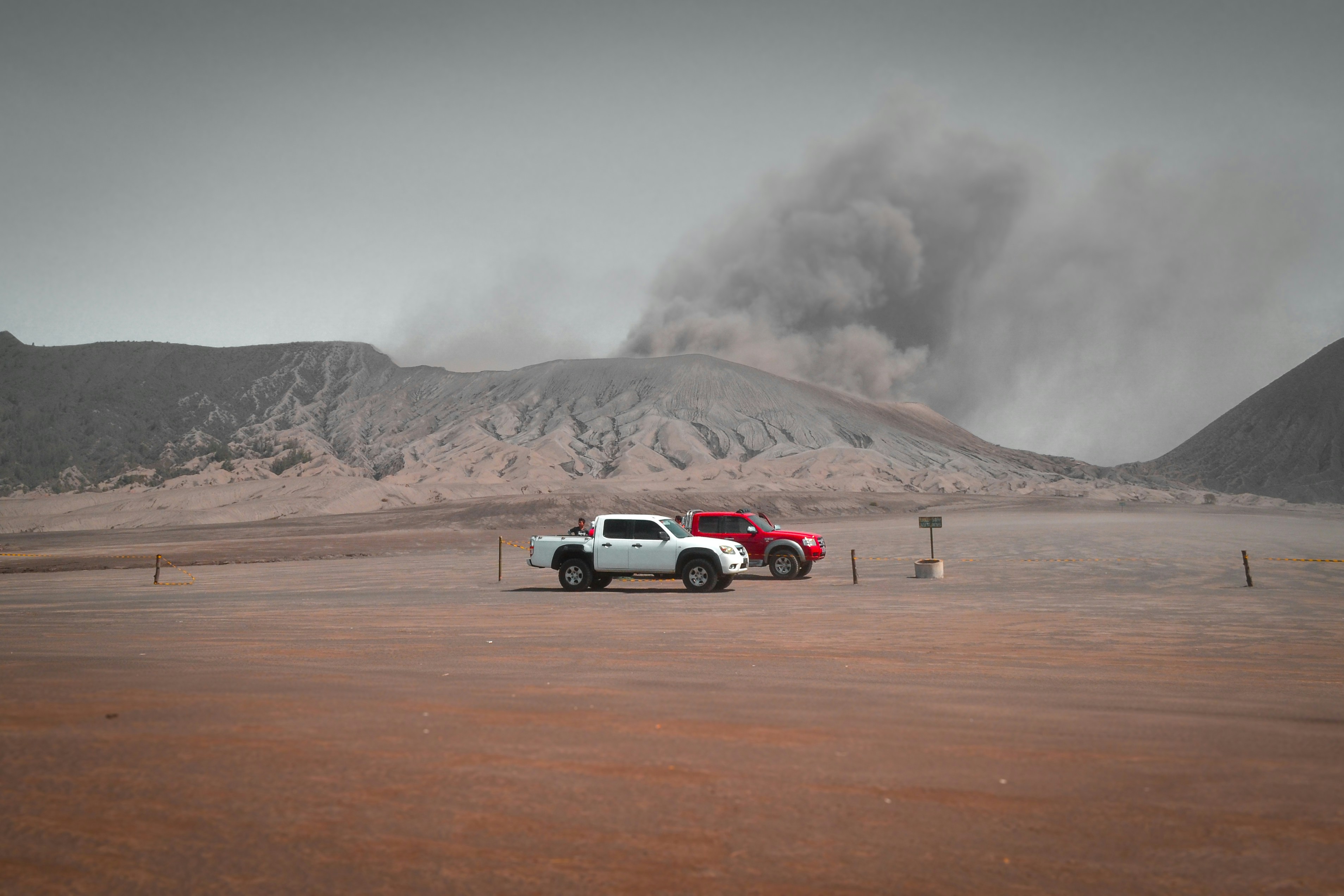 Red and white trucks get ready for adventure at volcano mountain