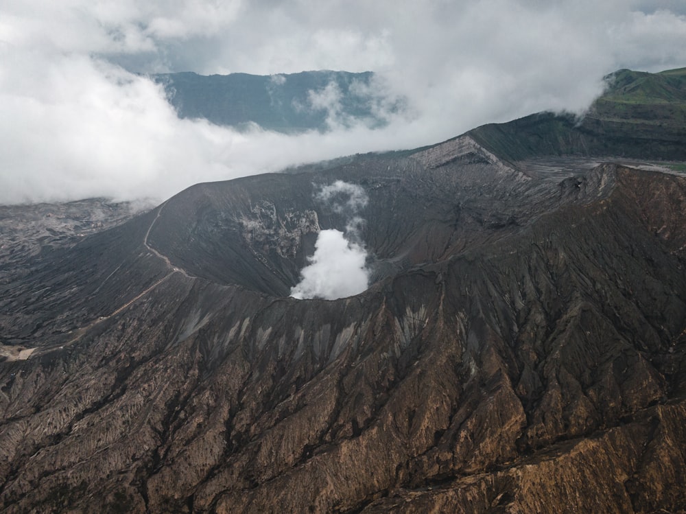 brown and green mountain under white clouds and blue sky during daytime