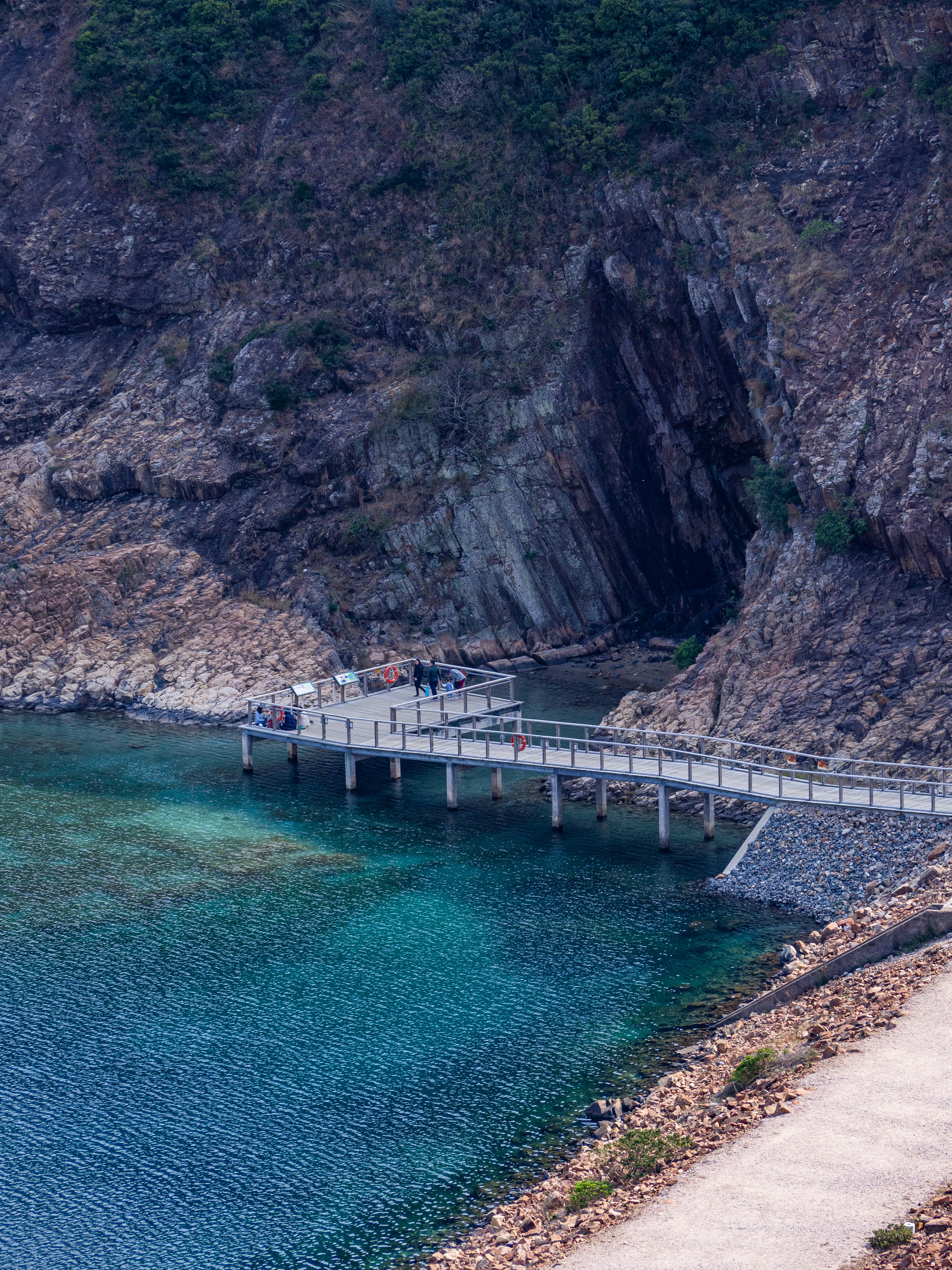 white boat on body of water near brown mountain during daytime