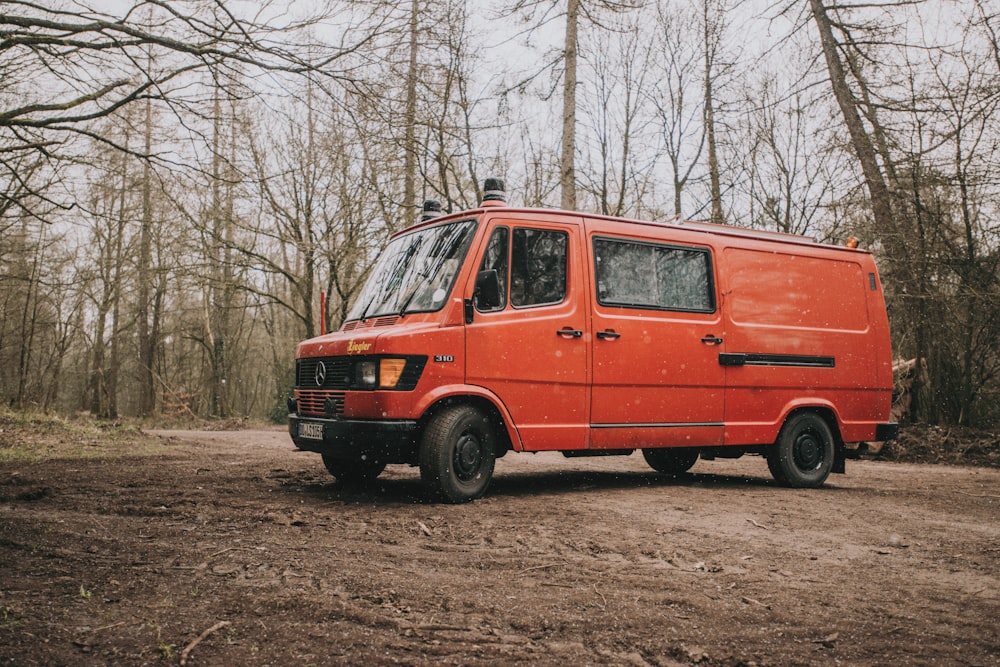 red van parked on brown field during daytime