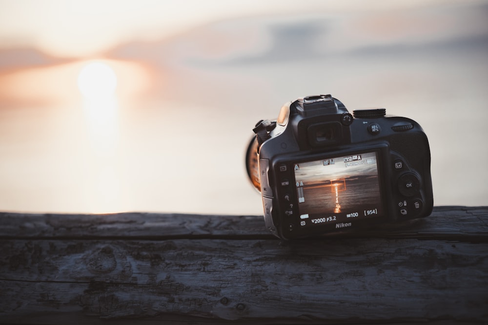 black dslr camera on brown wooden table