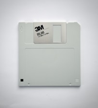 A gray 3.5-inch floppy disk featuring the 3M logo and labeled as DS, DD with a capacity of 1.0 MB. It is set against a plain white background.