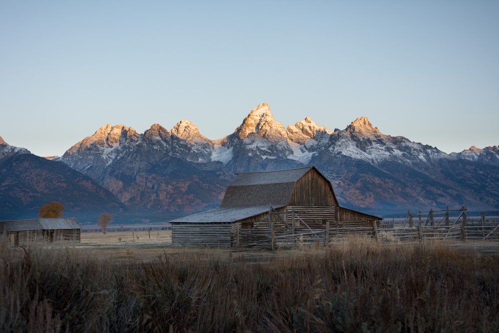 brown wooden house near brown mountain during daytime