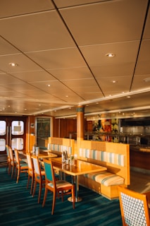 A warmly lit dining area with wooden chairs and walls decorated with family photos and maritime accents.