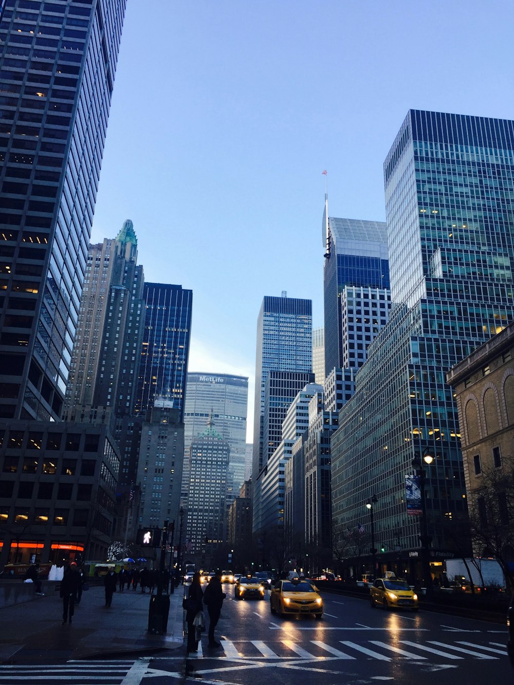 cars on road between high rise buildings during daytime