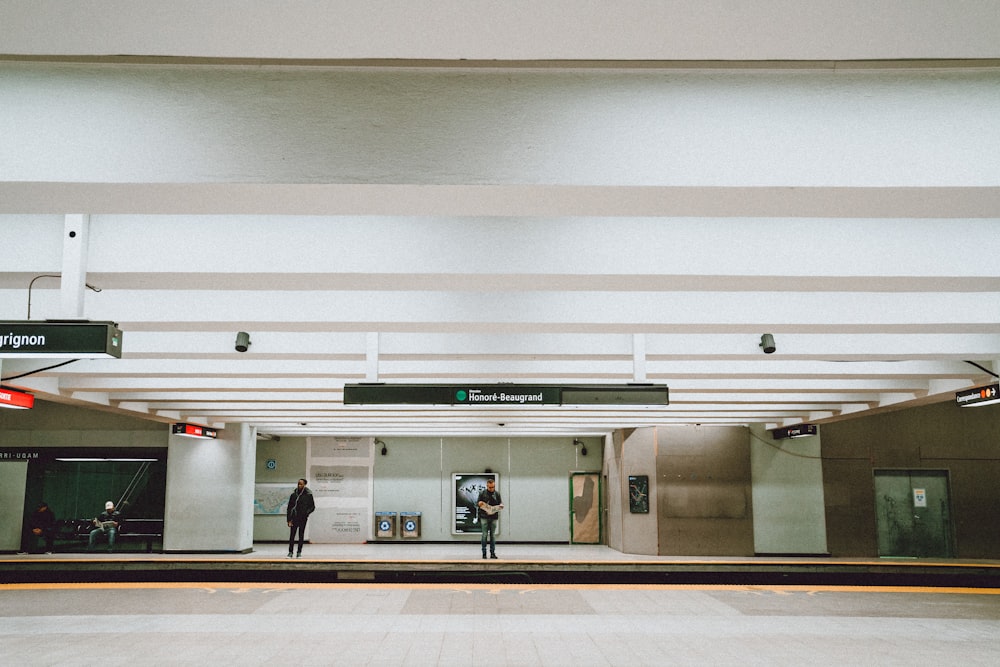 people walking on white and gray hallway