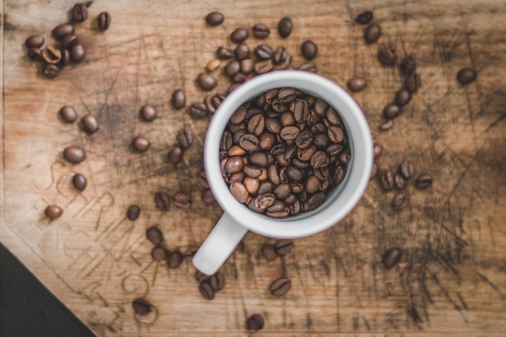 white ceramic mug with coffee beans