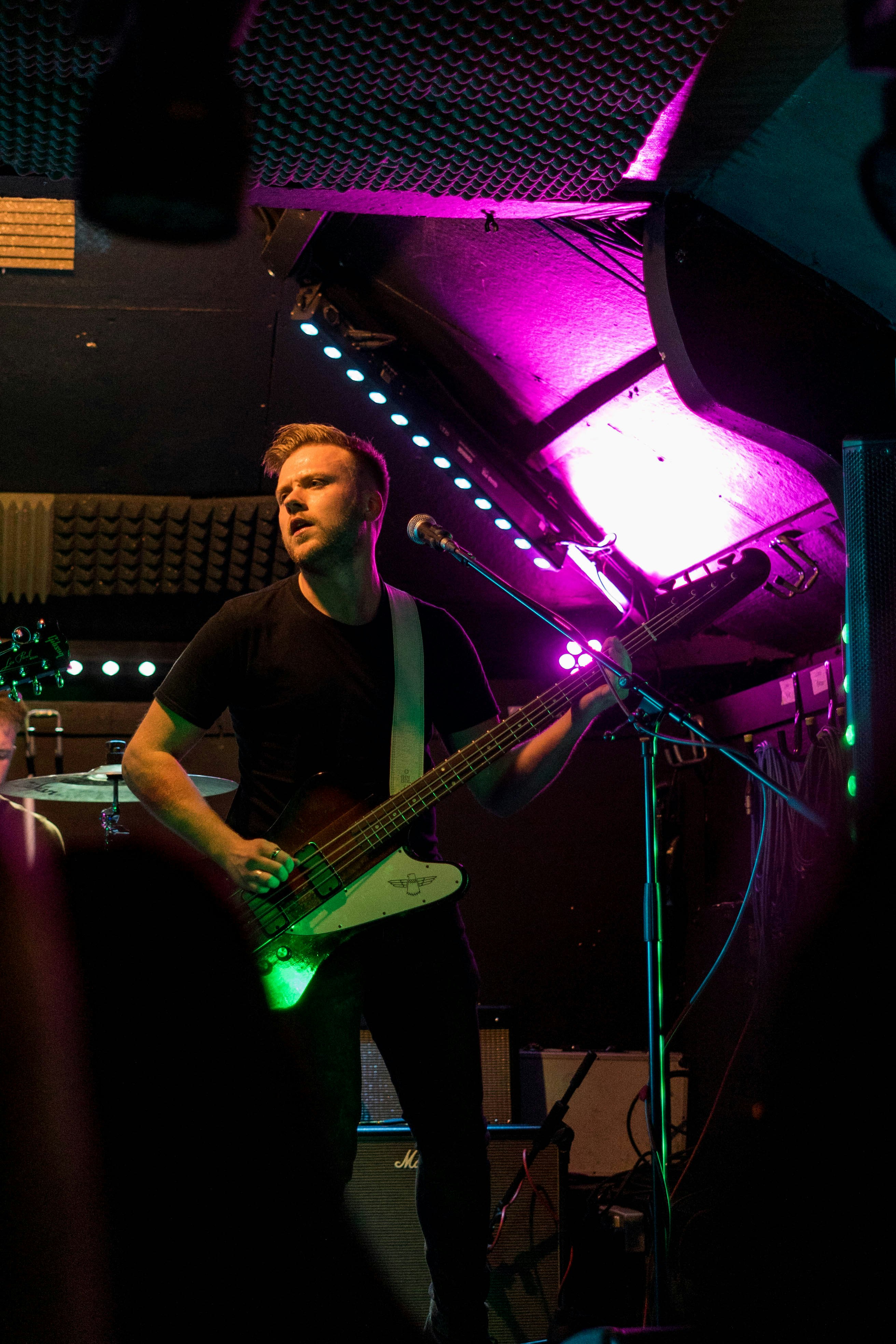 man in black t-shirt playing electric guitar
