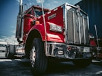 red and white truck on black asphalt road