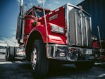 red and white truck on black asphalt road