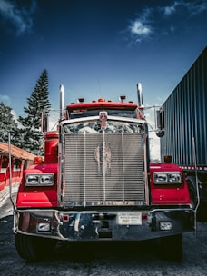 red and white freight truck on snow covered ground during daytime
