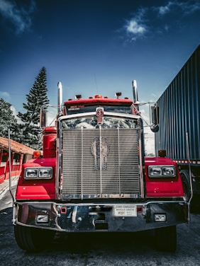 red and white freight truck on snow covered ground during daytime
