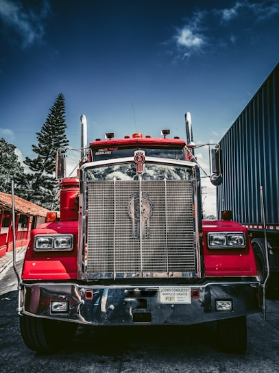 red and white freight truck on snow covered ground during daytime