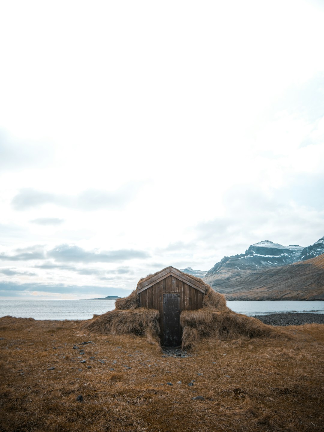 brown wooden house near body of water during daytime