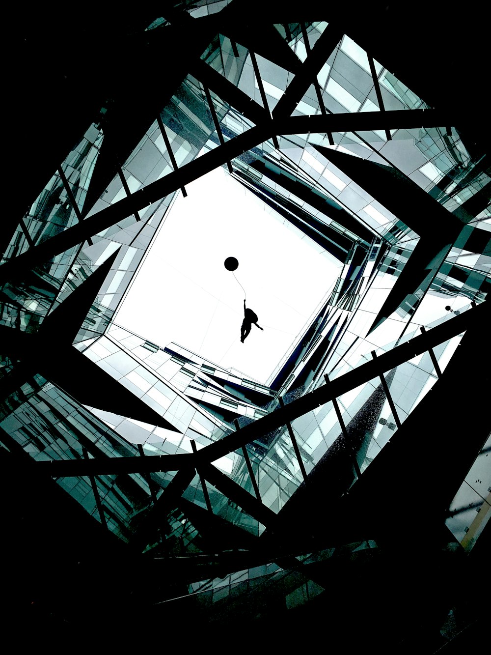 man in black jacket and pants standing on glass building