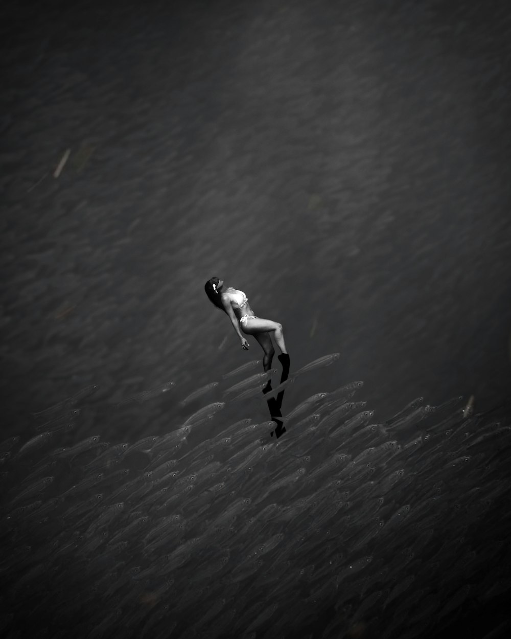 man in white shirt and black pants walking on black sand during daytime