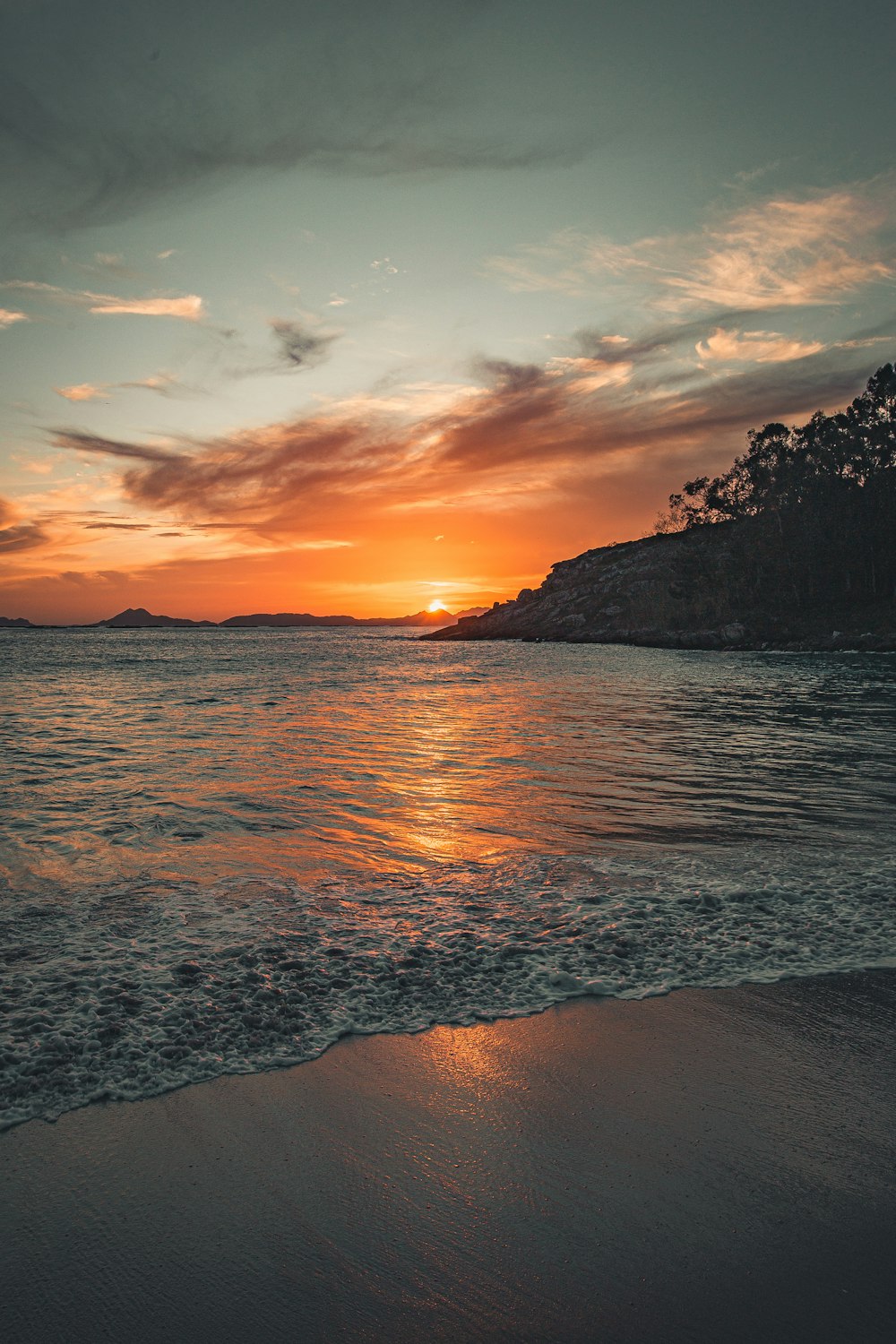 body of water near mountain during sunset