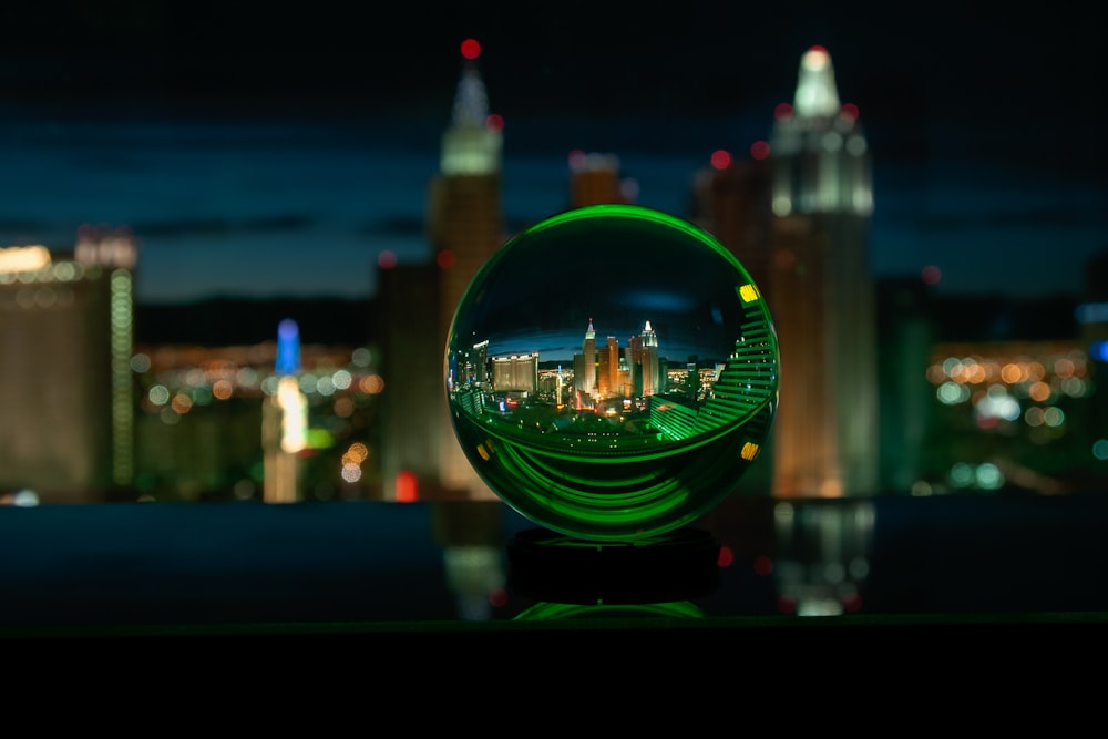 夜間の街の明かりと緑色のガラス玉