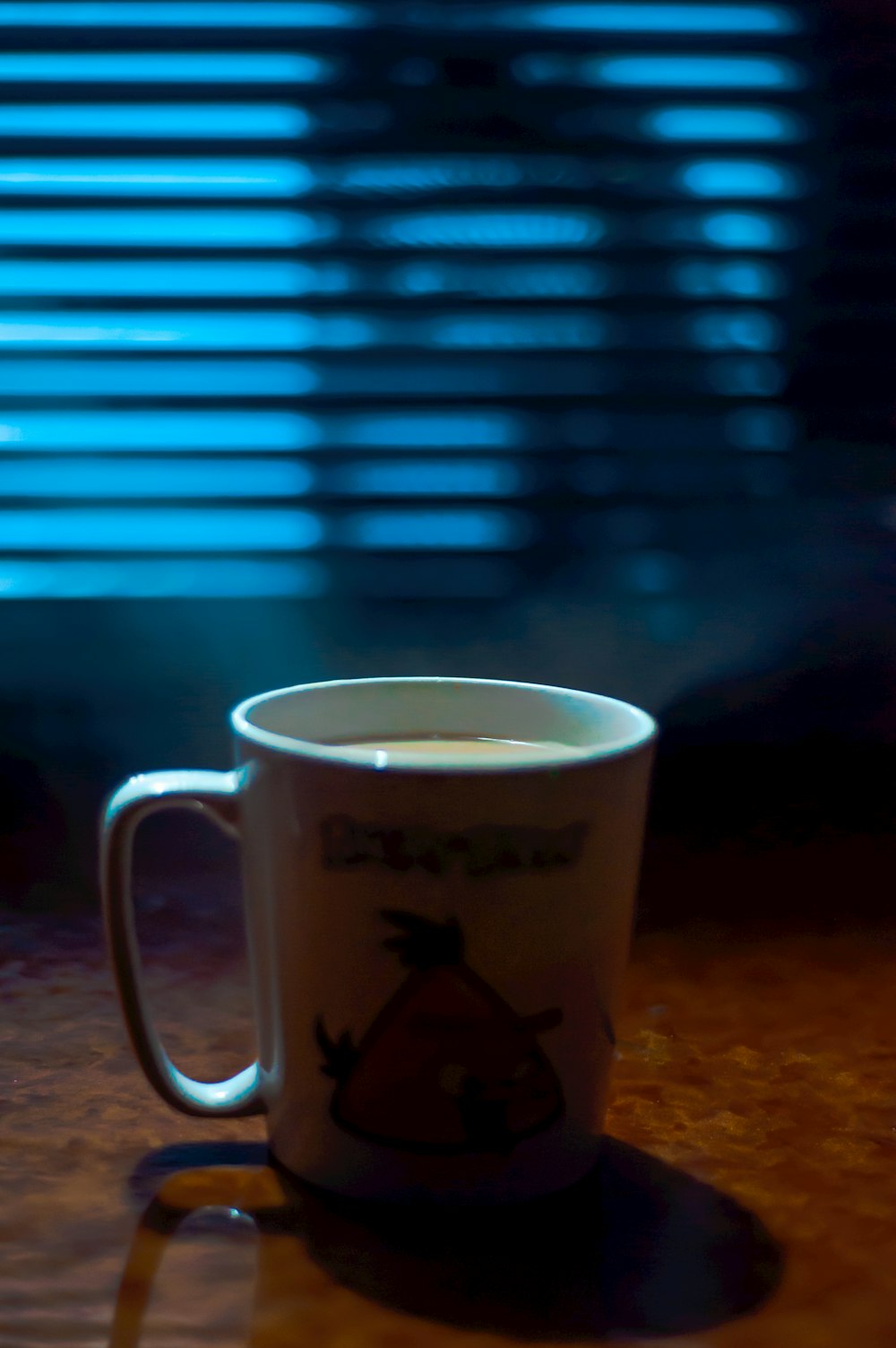 white and black ceramic mug on brown marble table