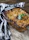 Close-up of a beautifully plated gluten-free lasagna with fresh herbs on a rustic table.