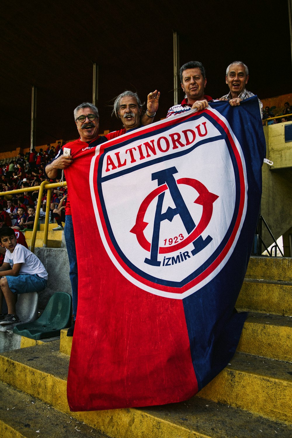 man in red and blue jersey shirt holding blue and red flag