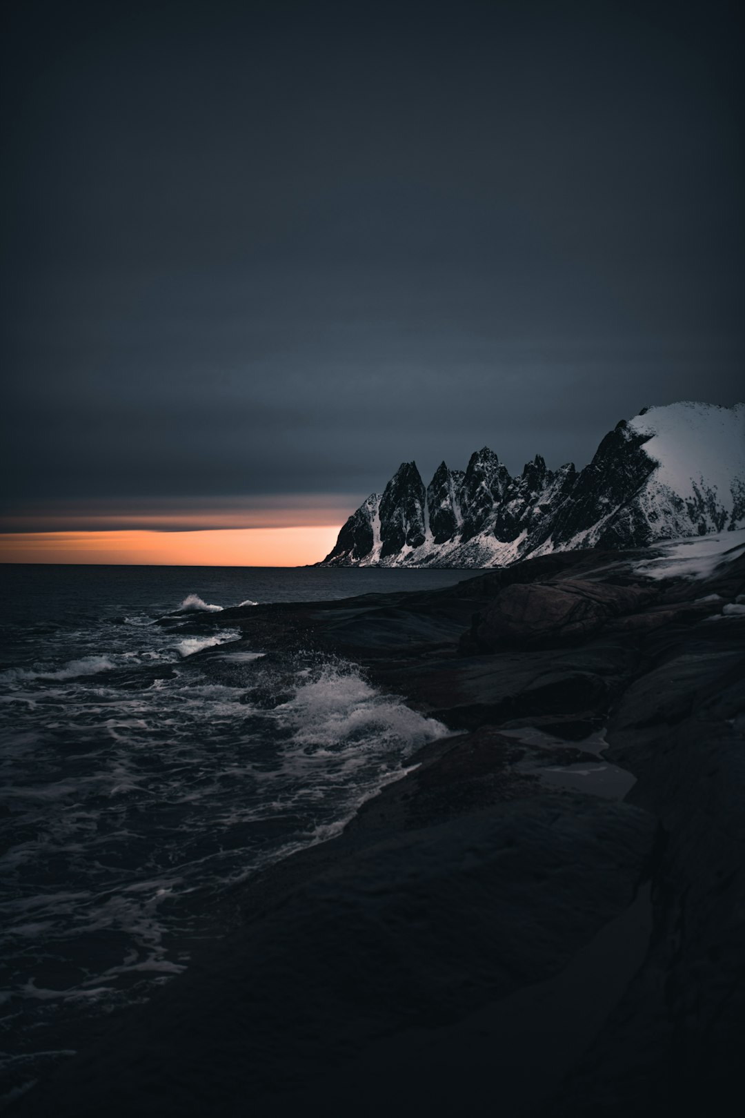 rocky mountain near body of water during sunset