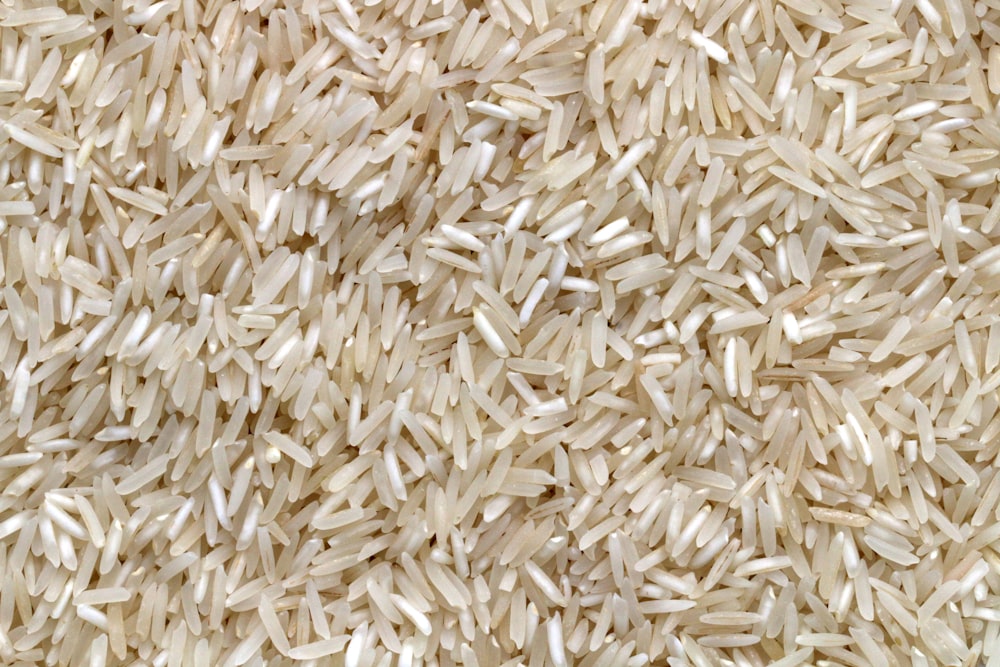 granos de arroz blanco sobre mesa de madera marrón