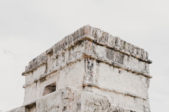 white concrete building during daytime in Zona Arqueológica de Tulum Mexico