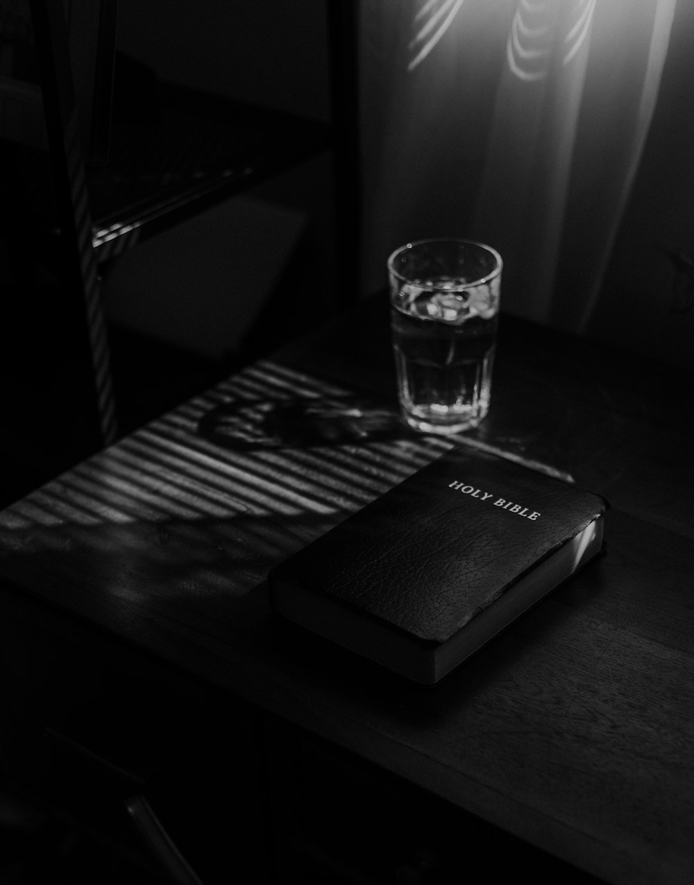 Foto en escala de grises de un vaso transparente sobre la mesa