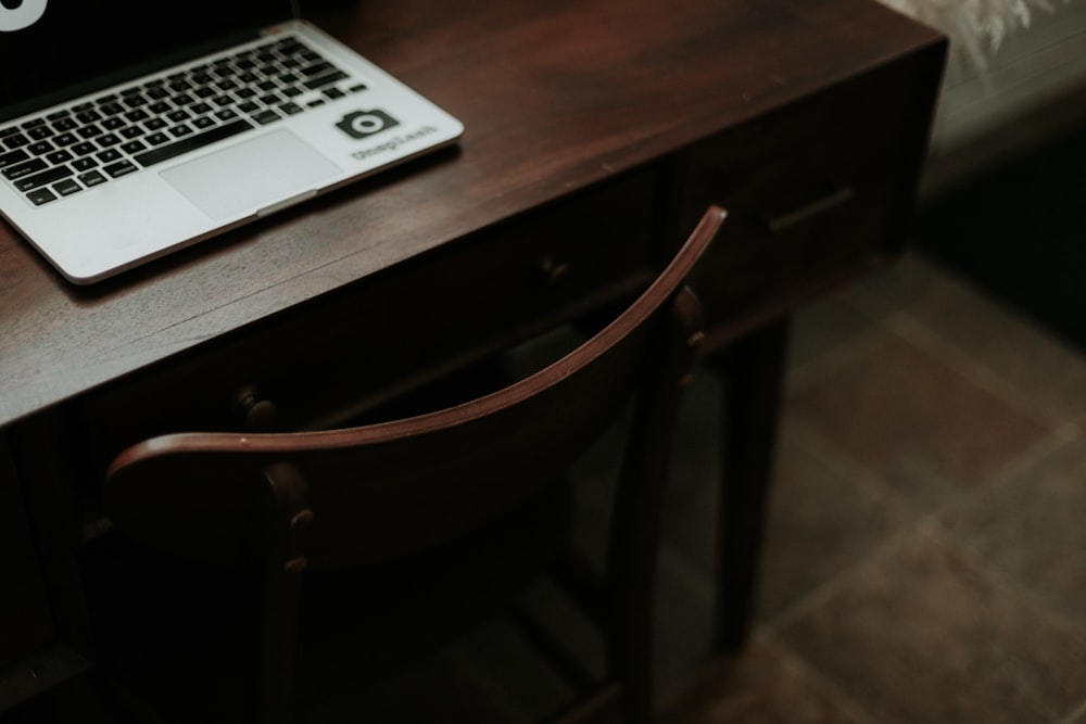 macbook pro na mesa de madeira marrom